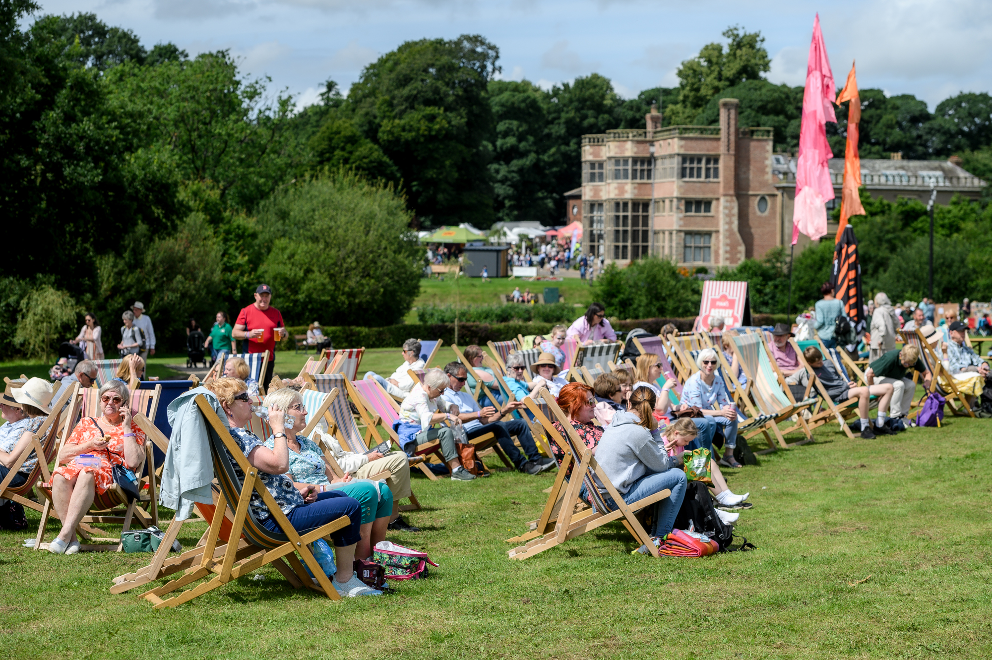 People sat in deckchairs with Astley Hall in the background